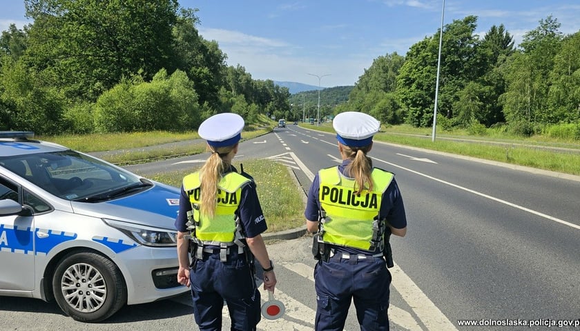 Na zdjęciu widać dwie policjantki z wydziału ruchu drogowego obserwujące przejeżdżające samochody