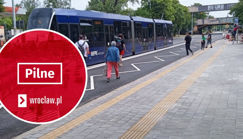 W tle: przystanek tramwajowy przy ul. Grabiszyńskiej, zdjęcie ilustracyjne. W kółku: czerwona plansza z napisem "pilne".