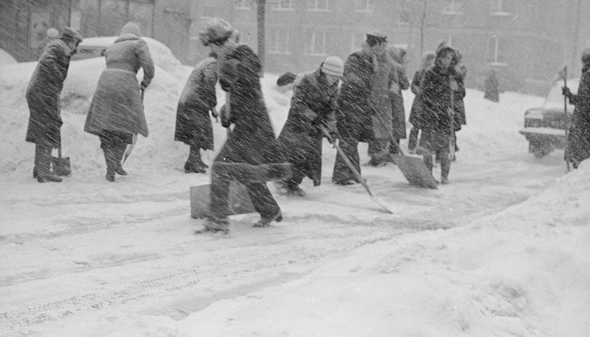 Mieszkańcy próbują wspólnie odśnieżyć ulicę podczas mocnych opadów śniegu