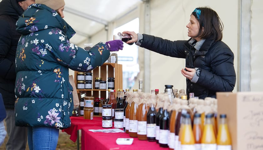 Dolnośląski Targ Rolny przy ul. Zwycięskiej. Wrocław, 24.01.2026. Na zdjęciu sprzedawczyni nalewająca klientce soku do kubeczka.