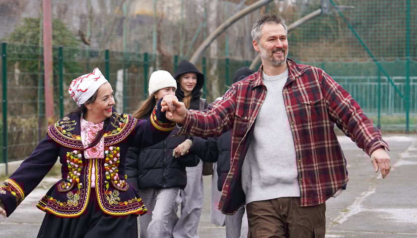 Kobieta i mężczyzna w pierwszej parze podczas poloneza na boisku szkolnym przy Pawiej, 25 stycznia 2026