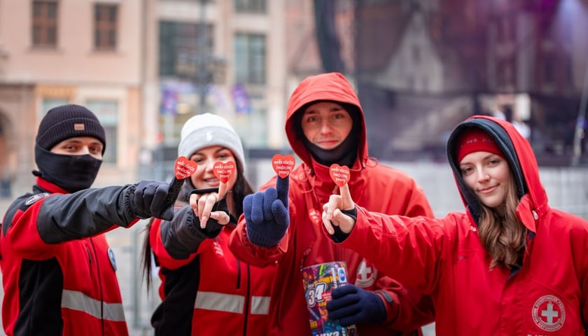 Grupa wolontariuszy podczas 34. Finału WOŚP we Wrocławiu z serduszkami Wielkiej Orkiestry