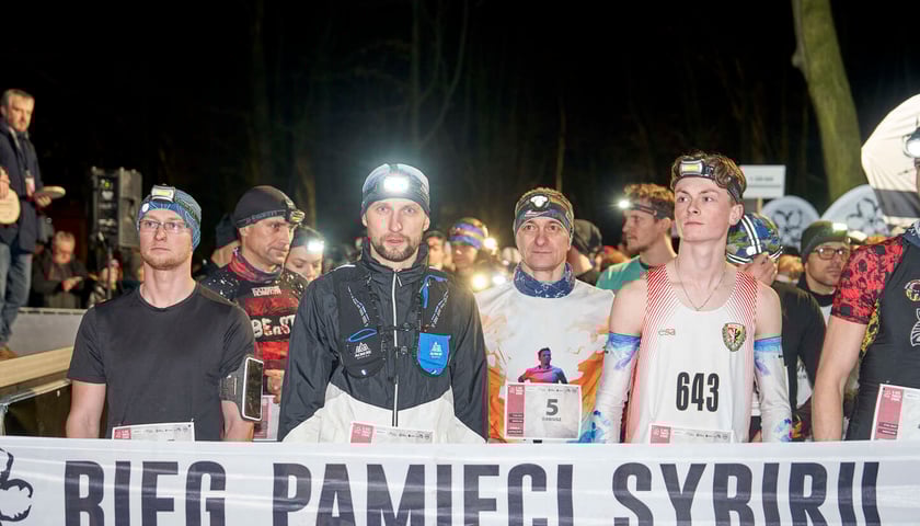 Biegacze przed startem podczas zeszłorocznej edycji przed taśmą z napisem "Bieg Pamięci Sybiru"