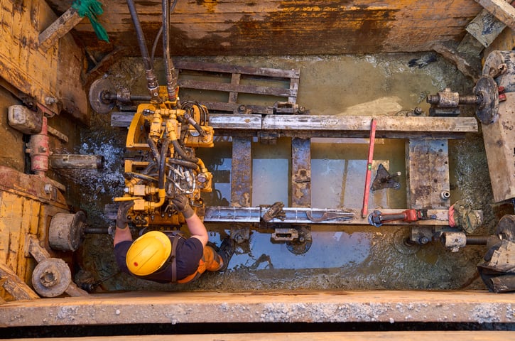 Robotnik w żółtym kasku w wykopie podczas rozbudowy sieci kanalizacyjnej na wrocławskich Strachowicach w marcu 2025 roku