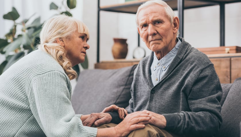 Starszy mężczyzna trzymający za ręce starszą kobietę - zdjęcie ilustracyjne.