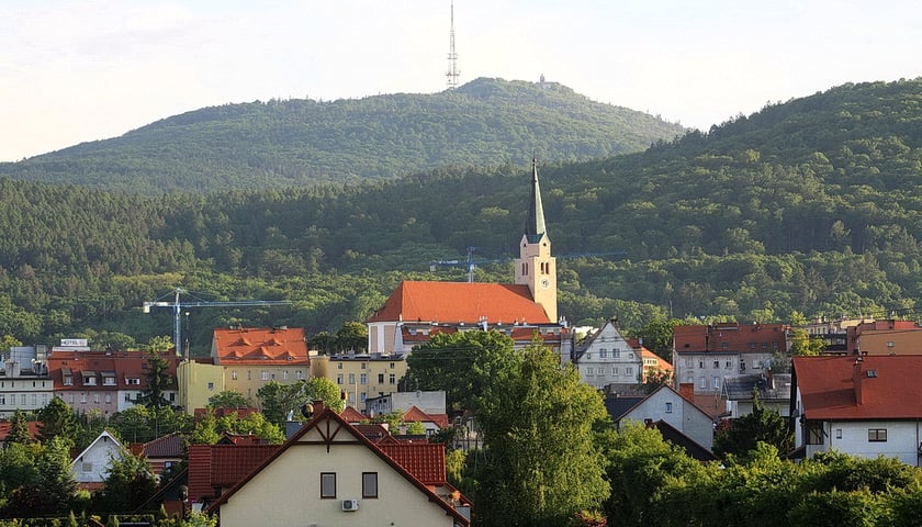 Panorama Sobótki z góra Ślężą w tle. Na zdjęciu widać miasteczko z górą w tle