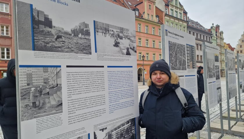 Patryk Pilch, jeden z autorów wystawy na tle przygotowanej przez siebie planszy