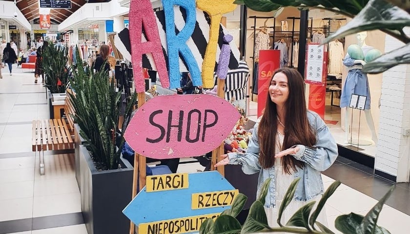 Na zdjęciu kobieta przy stoisku Targi Rzeczy Niepospolitych Artishop 