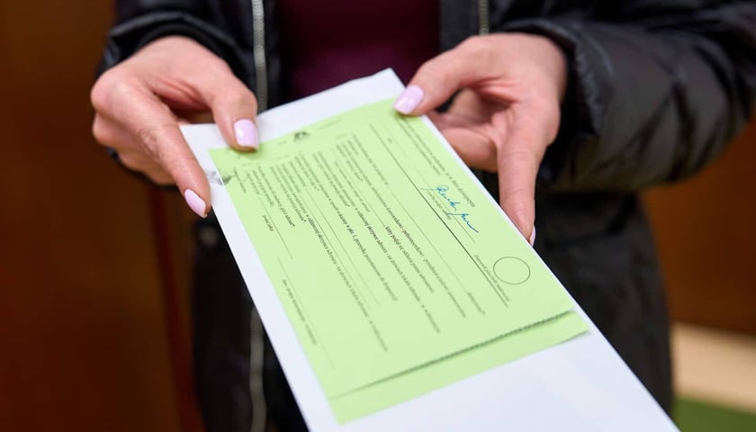 Kobieta ma w dłoniach kopertę z decyzją o podatku. Wrocławscy urzędnicy rozpoczynają doręczanie podatków od nieruchomości za 2026 rok 