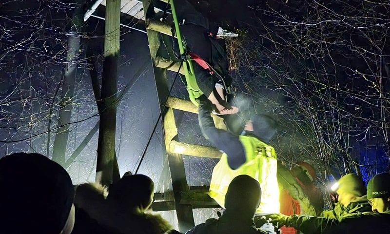 Policjanci ściągają wychłodzonego mężczyznę z ambony w lesie