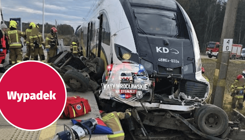 Pociąg KD i szczątki samochodu, w tle strażacy