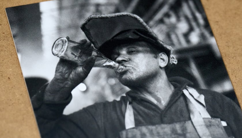 Jeden z pracowników Hutmenu pijący wodę mineralną z butelki - zdjęcie z wystawy "Niedziela w Hutmenie"