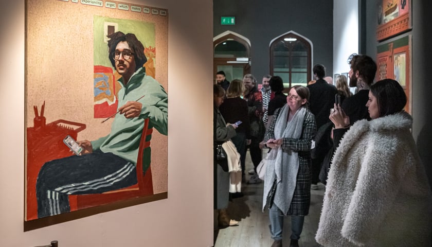 Zdjęcie z zeszłorocznego wernisażu. Ludzie oglądający prace artystów.