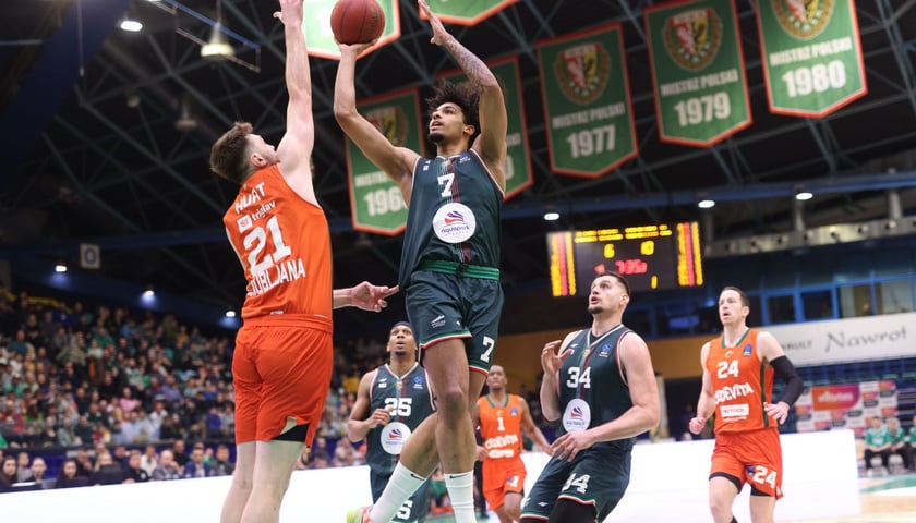 Jakub Urbaniak ze Śląska, w zielonej koszulce, w ataku na kosz w meczu EuroCup z Olimpią Ljubljana rozegranym w Hali Orbita. 