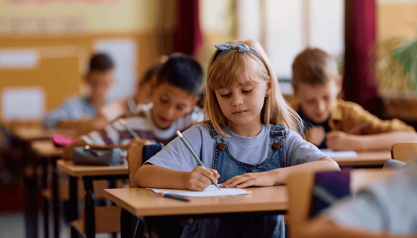 Dziewczynka w szkolnej ławce, zdjęcie ilustracyjne