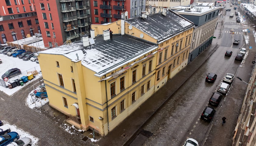 Remontowany dach kamienicy nr 33 przy ul. Tęczowej, pokryty śniegiem