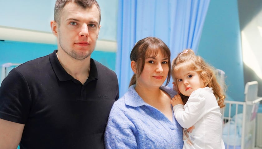 Na zdjęciu Zosia z rodzicami. Na zdjęciu mężczyzna i kobieta, która trzyma dziecko z rękach