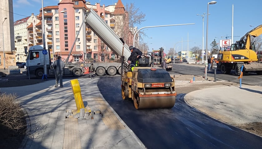 Drogowcy pracują przy układaniu masy bitumicznej na nowej drodze dla rowerów w ciągu ul. Długiej