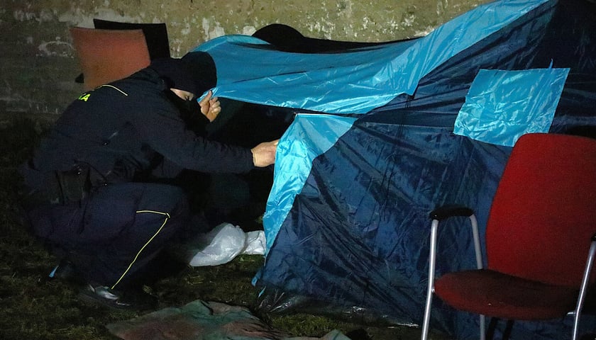 Strażnik miejski przy namiocie podczas akcji liczenia bezdomnych we Wrocławiu.