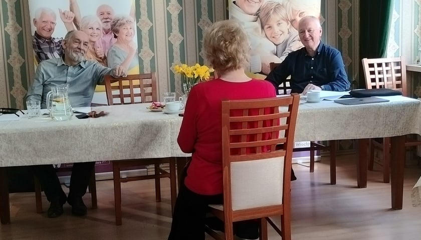 Zdjęcie ilustracyjne z jednego z poprzednich castingów: na pierwszym planie siedząca na krześle i odwrócona tyłem osoba, za stołem dwóch rozmawiających z nią mężczyzn