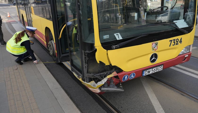 Policjantka sprawdza ślady na autobusie, który brał udział w wypadku