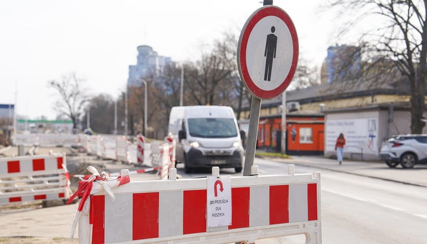 Ulica Kiełczowska, początek remontu. Na zdjęciu barierki, znak drogowy i ulica Kiełczowska