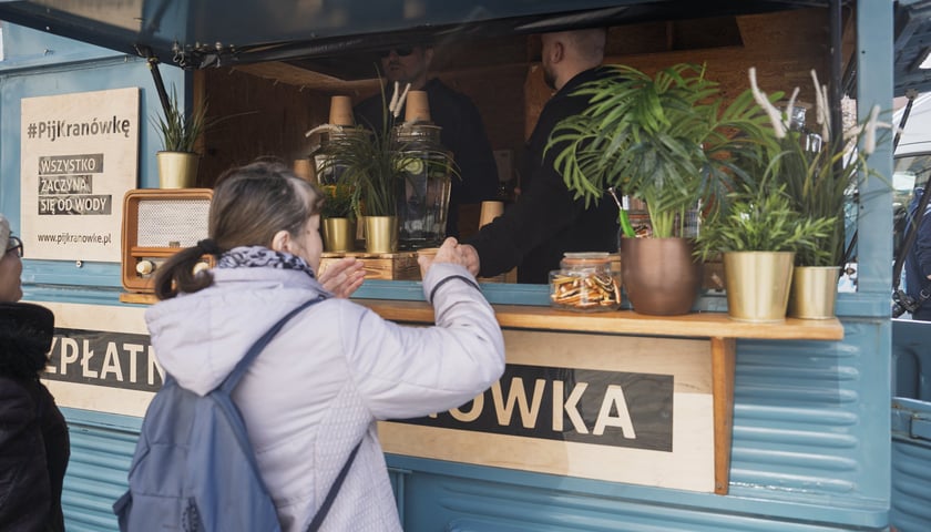 Zdjęcie z poprzedniej edycji Światowego Dnia Wody na Placu Solnym - kobieta stoi przy kiosku serwującym bezpłatną kranówkę