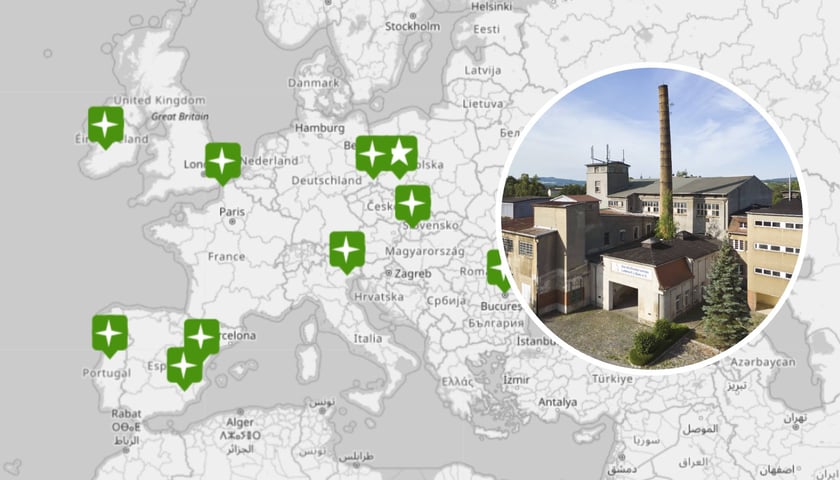W tle - mapa z zaznaczonymi uczestnikami projektu „GreenPlace. Let's do it together!". W kółku - Dawna fabryka makaronów w Löbau. Na zdjęciu widoczne są budynki fabryczne, komin oraz niebo z chmurami.