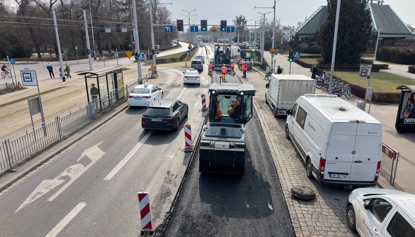 Układanie masy bitumicznej na ulicy Powstańców Śląskich między Orlą a Krzycką