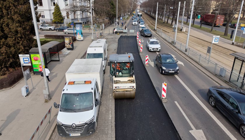 Układanie masy bitumicznej na ulicy Powstańców Śląskich między Orlą a Krzycką