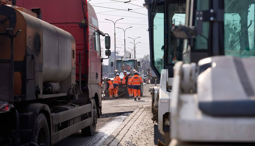 Układanie masy bitumicznej na ulicy Powstańców Śląskich między Orlą a Krzycką