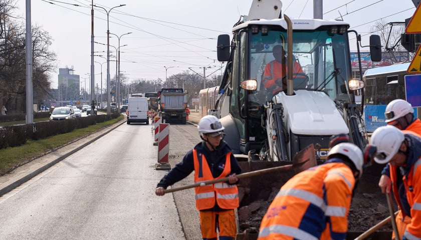 Układanie masy bitumicznej na ulicy Powstańców Śląskich między Orlą a Krzycką