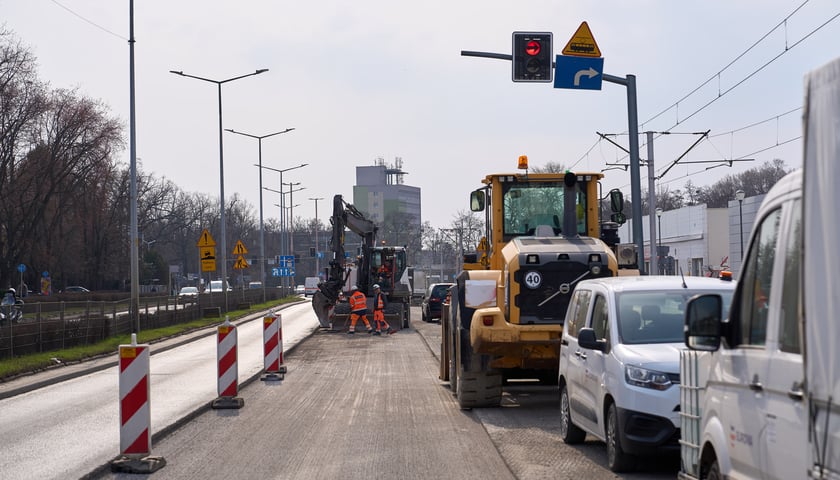 Układanie masy bitumicznej na ulicy Powstańców Śląskich między Orlą a Krzycką