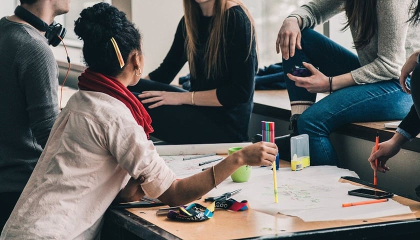 Jedną z form wsparcia dla NGO w Programie Równych Praw są stacjonarne warsztaty. Na zdjęciu pięcioro młodych ludzi rozmawiających przy stoliku. Zdjęcie ilustracyjne. 