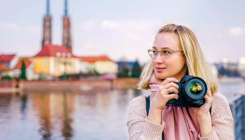 Kobieta z aparatem w rękach, zdjęcie ilustracyjne