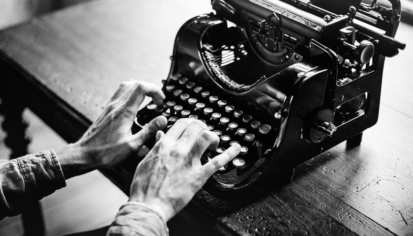 Dłonie mężczyzny piszącego na starej maszynie do pisania, zdjęcie ilustracyjne
