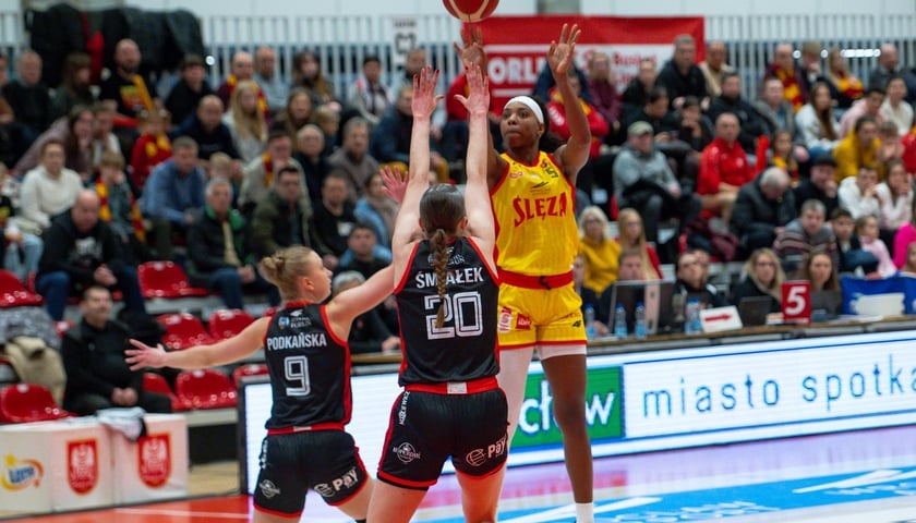 Koszykarka Ślęzy Wrocław Gmrice Davis z piłką rzuca na kosz drużyny Energa Toruń. W tle kibice w KGHM Arena na Kłokoczycach.