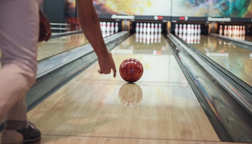 Na zdjęciu tor w kręgielni. Gracz gra w kręgle. Zdjęcie ilustracyjne