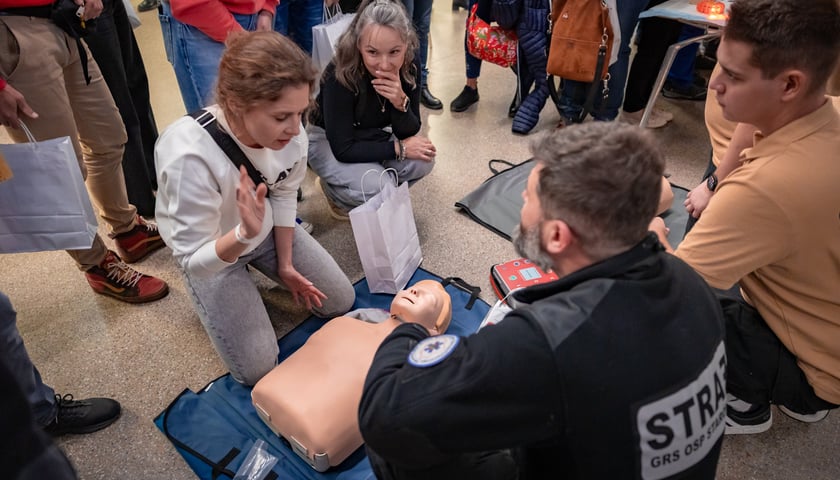 Uczennice  rozmawiają ze strażakiem o zasadach udzielania pierwszej pomocy