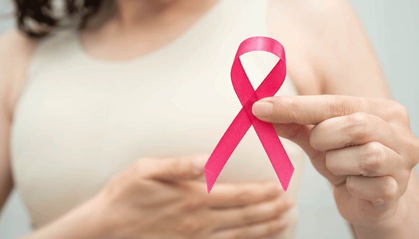 Kobieta trzymająca różową wstążką, która jest międzynarodowym symbolem walki z rakiem piersi, zdjęcie ilustracyjne