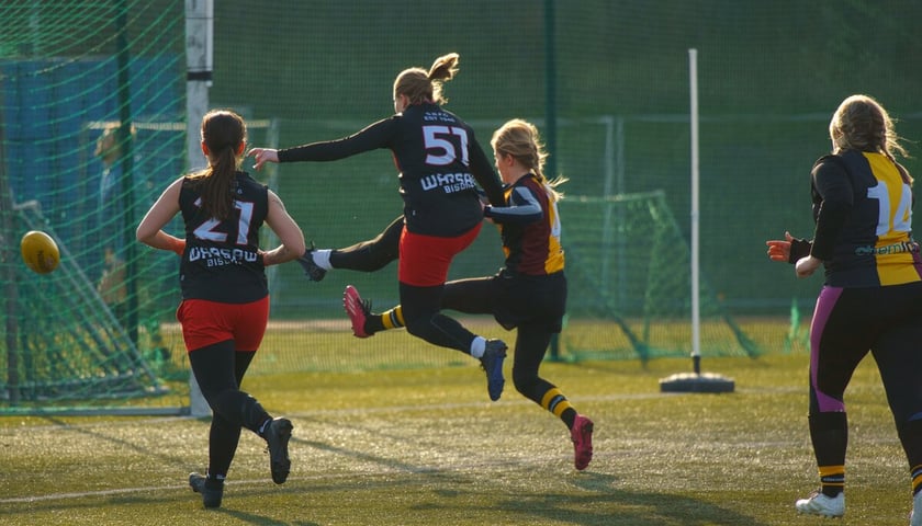 Towarzyski mecz drużyn kobiet - Wrocław Lions vs Warsaw Bisons. Piłkę kopie Aleksandra Kozioł z Wrocławia w żółtej koszulce.