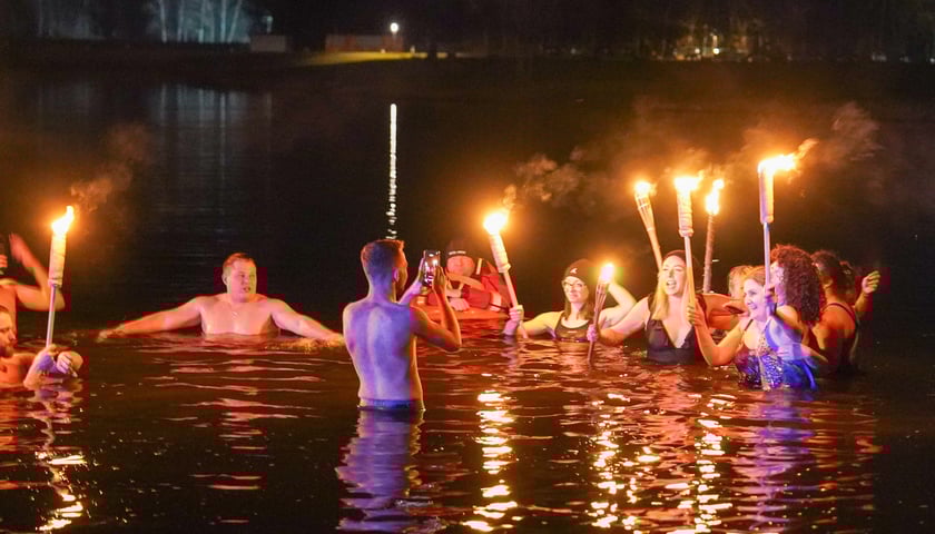 Na zdjęciu ludzie w wodzie z pochodniami podczas morsowania 21 marca - Kopalnia Wrocław Strfa Wakacji