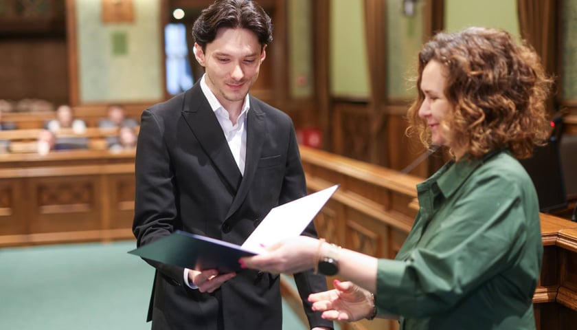 Uroczystość wręczenia miejskich stypendiów w Ratuszu. Stypendysta odbiera dyplom z rąk Agnieszki Rybczak, przewodniczącej Rady Miejskiej Wrocławia