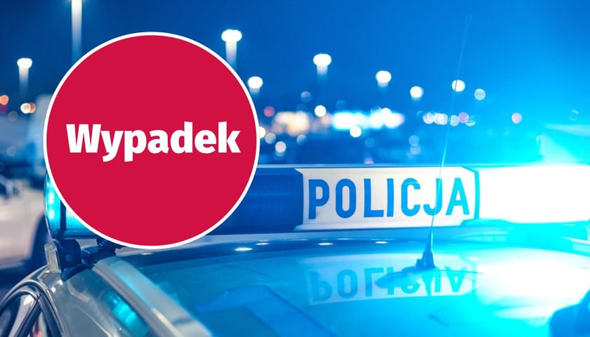 W kółku z lewej napis "wypadek", w tle "kogut" policyjnego radiowozu