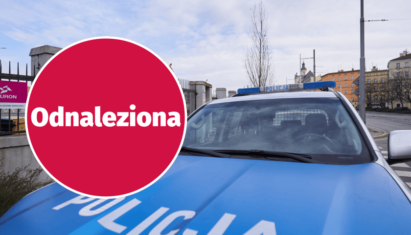 Napis "odnaleziona" w kółku, na maski tle policyjnego radiowozu