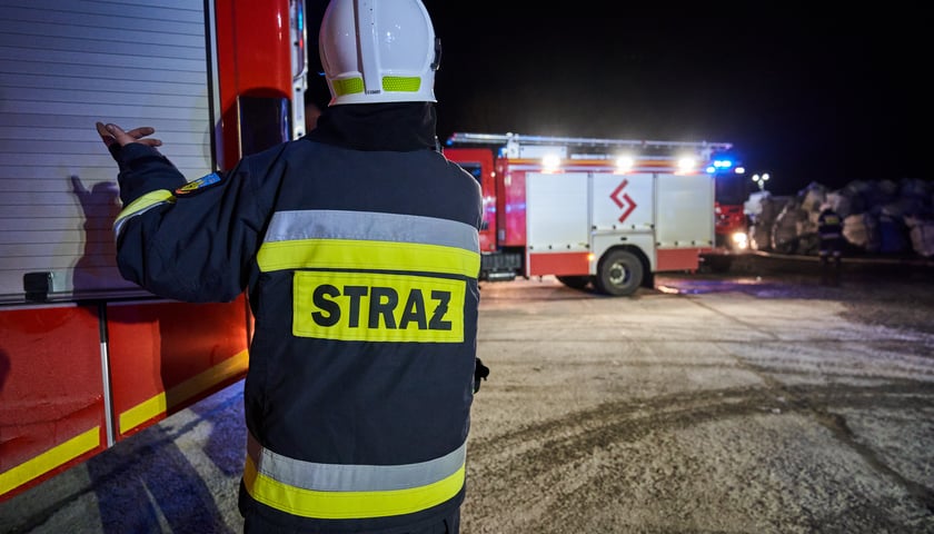 Straż pożarna - strażak na tle wozów, zdjęcie ilustracyjne z innego pożaru