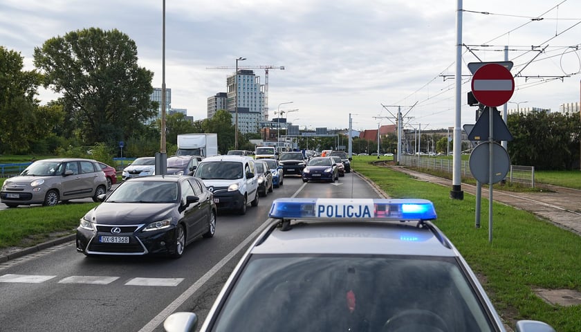 Policja, kogut policyjny na tle samochodów