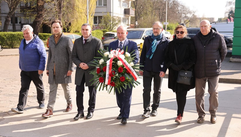 Składanie kwiat&oacute;w pod tablicą Jerzego Szmajdzińskiego