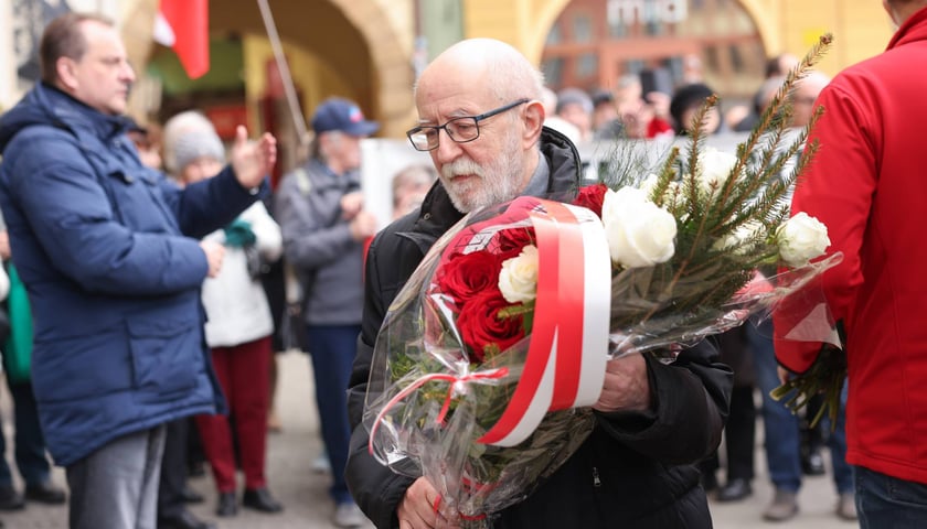 Składanie kwiat&oacute;w pod tablicą Aleksandry Natalii-Świat