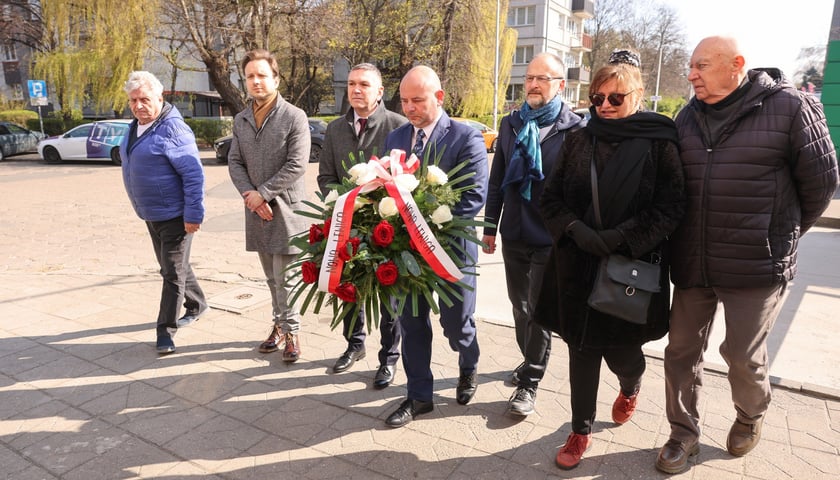 Składanie kwiat&oacute;w pod tablicą Jerzego Szmajdzińskiego